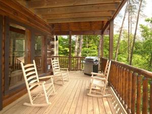 eine Veranda mit Stühlen und einem Grill auf einer Hütte in der Unterkunft Diamond Mine Holiday home in Gatlinburg
