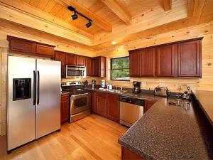 a kitchen with a stainless steel refrigerator and wooden cabinets at Diamond Mine Holiday home in Gatlinburg