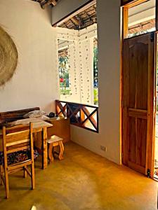 a room with a table and a window and a door at Palm House&Restaurant in Utende