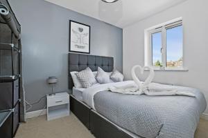 Un dormitorio con una cama con una escultura de cisne. en Modern 5BR Stay for Work & Groups, en Watford