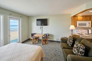 Una habitación de hotel con una cama, un sofá y una mesa. en Ground Floor Fireplace Studio - Ocean View & Beach Access - Pool and Hot Tub, en Lincoln City