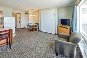 a living room with a couch and a tv and a table at Corner Oceanview King Suite Full Kitchen Beach Access Pool & Hot Tub in Lincoln City