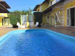 a swimming pool in front of a house at Pousada Village in Florianópolis
