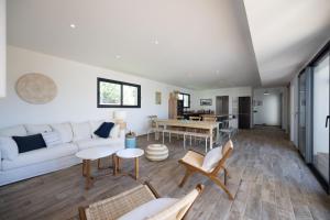 a living room with a white couch and a table at Villa vacances Bassin d'Arcachon in Gujan-Mestras +10 photos