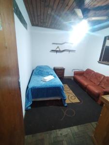 Una habitación con una cama y un sofá. en Hospedaje Cuaro, en Rivera