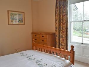 a bedroom with a bed with a dresser and a window at Shorley Lodge in Keswick +4 photos