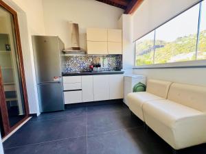 a small kitchen with white cabinets and a window at "Sweet Life" Casa Vacanze in Lipari