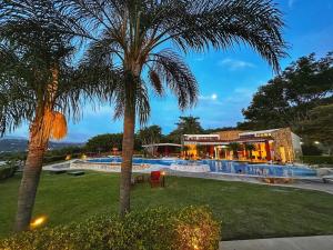 a resort with a palm tree and a swimming pool at CR MARIPOSA RENTALS Brand New lake view Penthouse with office space in Santa Ana