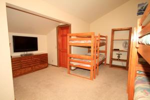 ein Schlafzimmer mit einem Etagenbett und einem TV in der Unterkunft Mountainback #40, Loft, Corner in Mammoth Lakes