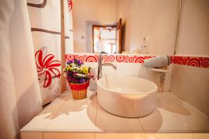 a bathroom with a sink and flowers on the counter at Picaflor Tambo Guest House in Ollantaytambo +73 photos