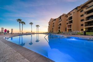 a large swimming pool with palm trees and buildings at Princesa 3BR 2BA OV Penthouse- 502D in Campo del Medio