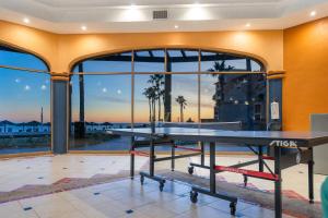un tavolo da ping pong in una stanza con grandi finestre di Princesa 3BR 2BA OV Penthouse- 502D a Campo del Medio
