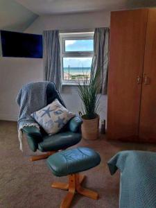 un soggiorno con una sedia e una finestra di Seaside Chill a Carrick