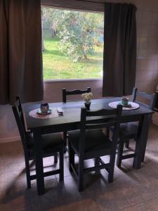 a dining room table and chairs with a window at Tu Casa en la Naturaleza in San Carlos de Bariloche +4 photos