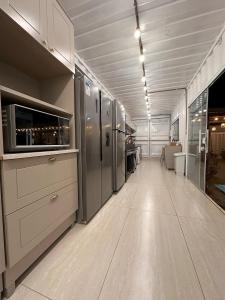 an empty room with a kitchen with stainless steel appliances at Casa Villela na Villela Home Stay Lago Sul in Brasilia