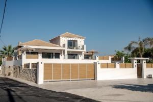 a white house with a brown garage door at Anar Luxury Villas in Kalamaki