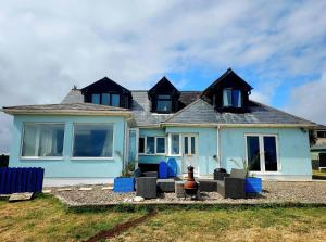 una casa blu con sedie blu davanti di Seaside Chill a Carrick
