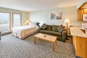 une chambre d'hôtel avec un lit et un canapé dans l'établissement Oceanfront Fireplace Suite - Full Kitchen - Pool & Hot Tub, à Lincoln City