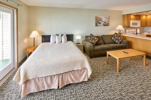 une chambre d'hôtel avec un lit et un canapé dans l'établissement Oceanfront Fireplace Suite - Full Kitchen - Pool & Hot Tub, à Lincoln City