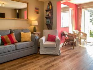 a living room with a couch and two chairs at Kippy Cottage in Porthtowan