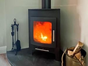 a stove with a fire in a room at Kippy Cottage in Porthtowan
