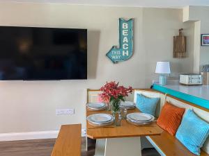 a dining room table with chairs and a tv at Kippy Cottage in Porthtowan