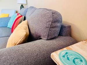 a couch with a blanket on the back of it at Kippy Cottage in Porthtowan