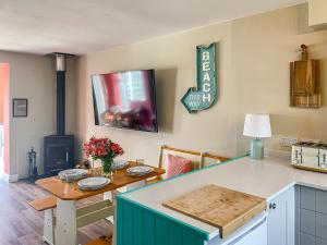 a kitchen with a table and a stove at Kippy Cottage in Porthtowan +25 photos