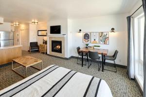 a living room with a bed and a table and a fireplace at Oceanfront Suite - King Bed - Heated Indoor Pool & Hot Tub in Lincoln City