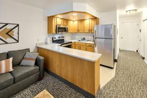 a kitchen with a couch and a stainless steel refrigerator at Oceanfront Suite - King Bed - Heated Indoor Pool & Hot Tub in Lincoln City