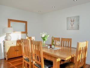 a dining room table with chairs and a table with wine bottles at Wonkey Donkey Cottage in Seaton