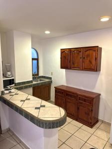 eine Küche mit Holzschränken und einer Arbeitsplatte in der Unterkunft Casa Brisa in Puerto Vallarta