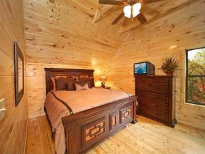 ein Schlafzimmer mit einem Bett in einem Blockhaus in der Unterkunft Firefly Lodge Holiday home in Gatlinburg