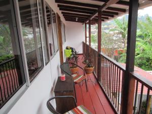 a balcony with chairs and tables on a house at Casa La Eliana in Salento