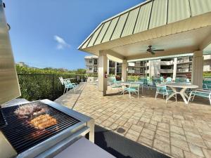 einen Grill auf einer Terrasse mit Tischen und Stühlen in der Unterkunft End Unit Steps from Beach Access w/ No Crazy Beach Prices in Marco Island + 34 Fotos