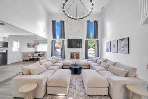 a living room with a large couch and a fireplace at Lux Family Stay with Heated Pool, Spa, Theater, Game Room in Spring