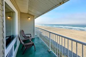 a porch with a rocking chair and the beach at Oceanfront Family Suite - Full Kitchen - Beach Access - Pool & Hot Tub in Lincoln City