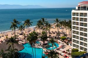 a view of the beach and the ocean from a resort at Spacious, standard with beach access & wifi! in Puerto Vallarta