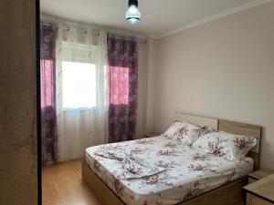 a bedroom with a bed and a window at Diora's Apartment in Durrës