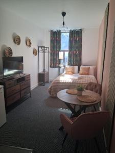 a bedroom with a bed and a table and a tv at Crown House Studio Apartment in Birmingham