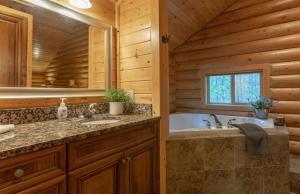 a bathroom with a tub and a sink in a log cabin at Summer Adventure Awaits! Hidden Pines- Yellowstone in Island Park +43 photos