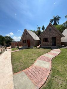 a house with a brick walkway in front of a yard at Chalés Paraíso Guararema 4 in Guararema