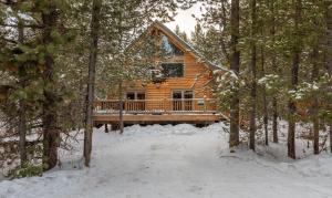 a log cabin in the woods in the snow at Summer Adventure Awaits! Hidden Pines- Yellowstone in Island Park