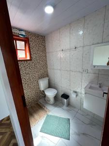 a bathroom with a toilet and a sink at Chalés Paraíso Guararema 4 in Guararema