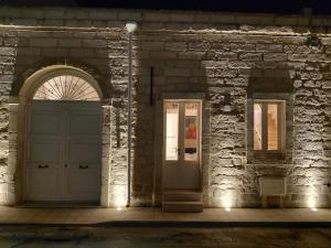 an entrance to a stone building with a white door at La Dimora dei Sapienti Luxury House in Melendugno