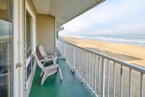 ein Hausbalkon mit einem Stuhl und dem Strand in der Unterkunft Stunning Oceanfront Suite - Full Kitchen - Heated Indoor Pool & Hot Tub in Lincoln City