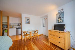 a bedroom with a table and a kitchen with a dining room at Studio Les Cordeliers centre ville pres du marche in La Rochelle +14 photos