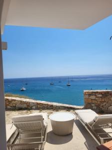 a view of the ocean from a patio with chairs and a tub at CASA GIGLIO Folegandros in Agali