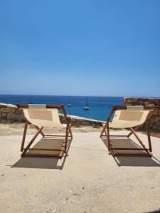 two beach chairs sitting on the sand near the ocean at CASA GIGLIO Folegandros in Agali