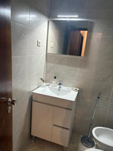 a bathroom with a sink and a toilet and a mirror at Bem Estar in Chaves